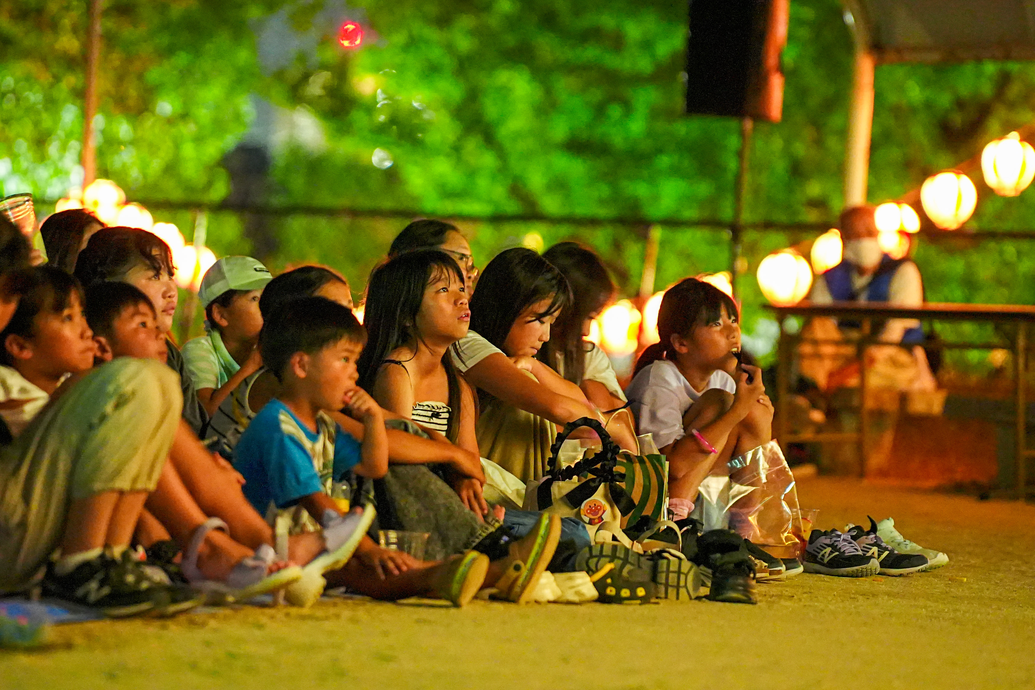 くじら映画祭の様子 - 提灯の灯りの中で映画を楽しむ子どもたち